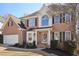 Charming brick two-story home featuring black shutters, a manicured lawn and a two car garage at 1110 Croftmoore Lndg, Suwanee, GA 30024