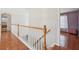 This is a hallway at the top of the stairs featuring hardwood floors, and white banisters at 1110 Croftmoore Lndg, Suwanee, GA 30024