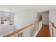 Upstairs hallway bathed in natural light and featuring hardwood floors, a view to the outside, and access to other rooms at 1110 Croftmoore Lndg, Suwanee, GA 30024