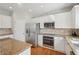 This kitchen has stainless steel appliances, including a microwave, oven and refrigerator, with white cabinets at 1110 Croftmoore Lndg, Suwanee, GA 30024