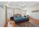 Spacious main bedroom with hardwood floors, tray ceiling, ceiling fan, and lots of natural light from multiple windows at 1110 Croftmoore Lndg, Suwanee, GA 30024