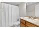 Well-lit bathroom with a white shower curtain, toilet, and a single sink vanity featuring light countertops at 1280 W Peachtree Nw St # 1712, Atlanta, GA 30309
