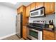 Cozy kitchen features wood cabinets, modern stainless steel appliances, and granite countertops at 1280 W Peachtree Nw St # 1712, Atlanta, GA 30309