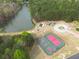 Beautiful aerial view showcasing the pond, pool, tennis and basketball courts surrounded by lush greenery at 2061 Emerald Dr, Loganville, GA 30052