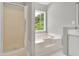 Bathroom featuring a walk-in shower, a jetted soaking tub, a large window, and neutral decor at 2061 Emerald Dr, Loganville, GA 30052