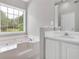 Bathroom with a double vanity, a large soaking tub with jets and a window, and neutral decor at 2061 Emerald Dr, Loganville, GA 30052