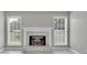Cozy fireplace with brick surround and mantle, flanked by large windows at 2061 Emerald Dr, Loganville, GA 30052
