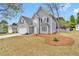 Charming two-story home with gray siding, attached garage, and tree in the front yard at 2061 Emerald Dr, Loganville, GA 30052