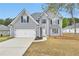 Charming two-story home with gray siding, attached garage, and well-manicured front yard at 2061 Emerald Dr, Loganville, GA 30052