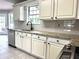 Bright kitchen features white cabinets, granite countertops, stainless steel appliances and gray tile backsplash at 2061 Emerald Dr, Loganville, GA 30052