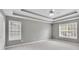 Spacious bedroom with tray ceiling, neutral paint and large windows at 2061 Emerald Dr, Loganville, GA 30052