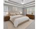Comfortable main bedroom featuring a tray ceiling, neutral decor, and large windows for natural light at 2061 Emerald Dr, Loganville, GA 30052