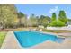Backyard pool with a concrete surround and patio seating near the green lawn at 2061 Emerald Dr, Loganville, GA 30052