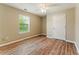 Bright bedroom featuring wood-look floors, neutral walls, and a large window at 3267 Forrest Bluff Way, Lithonia, GA 30038