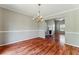 Dining room with chandelier and hardwood floors, leading into a living room with a fireplace at 3267 Forrest Bluff Way, Lithonia, GA 30038