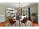 Elegant dining room with modern light fixture and view to kitchen with white cabinetry and island at 3267 Forrest Bluff Way, Lithonia, GA 30038