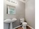 Cozy powder room featuring a pedestal sink, toilet, and wood-look flooring at 3267 Forrest Bluff Way, Lithonia, GA 30038