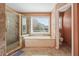 Bathroom featuring a soaking tub, a stand-up shower, and a window at 405 N Pine Dr, Alpharetta, GA 30022