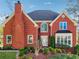 Charming two-story brick home with a well-manicured lawn and mature landscaping at 405 N Pine Dr, Alpharetta, GA 30022