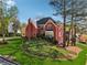 Expansive landscaped yard showcasing a two-story brick home with mature trees at 405 N Pine Dr, Alpharetta, GA 30022