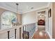 Upstairs hallway with an arched window, chandelier, and an open doorway to a bedroom at 405 N Pine Dr, Alpharetta, GA 30022