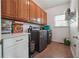 Bright laundry room features a washer, dryer, white countertop, and wooden cabinets at 405 N Pine Dr, Alpharetta, GA 30022