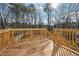 A wooden back deck featuring natural wood and railings overlooks a tranquil wooded area at 7902 West Shore Cir, Riverdale, GA 30296