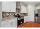Close up view of the stainless steel oven, granite countertops, and brick backsplash in the kitchen at 7902 West Shore Cir, Riverdale, GA 30296