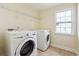 Bright laundry room with window, wire shelving, and front load washer and dryer at 7902 West Shore Cir, Riverdale, GA 30296