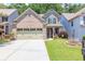 Charming two-story home featuring a brick facade, a two-car garage, and a well-maintained lawn at 2050 Harvest Ridge Cir, Buford, GA 30519