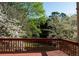 A view of the backyard from the wooden deck, surrounded by trees and foliage in full bloom at 2875 Factor Walk Blvd, Suwanee, GA 30024
