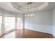 Dining room with hardwood floors, three large windows and modern chandelier at 2875 Factor Walk Blvd, Suwanee, GA 30024