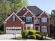 Traditional brick home featuring manicured lawn, two-car garage and classic architectural details at 2875 Factor Walk Blvd, Suwanee, GA 30024