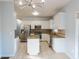 Bright kitchen with stainless appliances, center island, light colored cabinets, and tile floor at 2875 Factor Walk Blvd, Suwanee, GA 30024