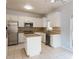 Well-lit kitchen with stainless steel appliances, center island, and tile flooring at 2875 Factor Walk Blvd, Suwanee, GA 30024