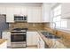Kitchen featuring granite countertops, stainless steel appliances, and tile backsplash at 2875 Factor Walk Blvd, Suwanee, GA 30024