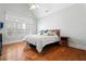 Bright bedroom featuring a large window with shutters, hardwood floors, and a neutral color scheme at 4045 Stephens Mill Ne Run, Atlanta, GA 30342