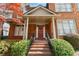 Inviting porch area with red door, brick steps, wrought iron railing, and manicured landscaping at 4045 Stephens Mill Ne Run, Atlanta, GA 30342