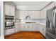 Bright kitchen featuring white cabinets, stainless steel appliances, and hardwood floors, blending style with functionality at 4045 Stephens Mill Ne Run, Atlanta, GA 30342