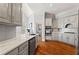 Modern kitchen with stainless steel appliances, marble counters, gray cabinets, and hardwood floors, creating a sleek cooking space at 4045 Stephens Mill Ne Run, Atlanta, GA 30342