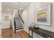 Inviting entryway with hardwood floors, a decorative table, and a staircase with black accents at 2068 Cortland Rd, Milton, GA 30009