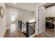 Bright hallway features hardwood floors, black metal railing, and an open door to the laundry room at 2068 Cortland Rd, Milton, GA 30009