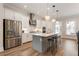 Spacious kitchen with stainless steel appliances, gray island, and hardwood floors at 2068 Cortland Rd, Milton, GA 30009