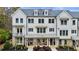 Charming three-story townhouse with white siding, dormer windows, and a covered front porch at 2068 Cortland Rd, Milton, GA 30009