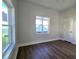 Well-lit bedroom featuring hardwood floors, and a window overlooking a neighborhood street at 2152 Castlewood St, East Point, GA 30344