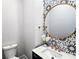 Stylish powder room featuring a round mirror and decorative patterned tile accent wall at 2152 Castlewood St, East Point, GA 30344