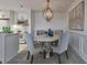 Dining room with round wooden table, comfortable upholstered chairs, modern chandelier, and open kitchen at 300 Johnson Ferry Ne Rd # A1008, Atlanta, GA 30328