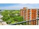 Brick apartment building with balconies overlooks green space with trees and an American flag on a sunny day at 300 Johnson Ferry Ne Rd # A1008, Atlanta, GA 30328