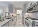 White kitchen with marble counters, gray flooring, black hardware and stainless steel appliances at 300 Johnson Ferry Ne Rd # A1008, Atlanta, GA 30328