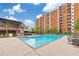 Large community pool featuring a spacious sun deck and comfortable seating, with a brick apartment building backdrop at 300 Johnson Ferry Ne Rd # A1008, Atlanta, GA 30328